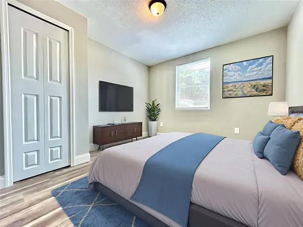 a bedroom with a bed and a flat screen tv