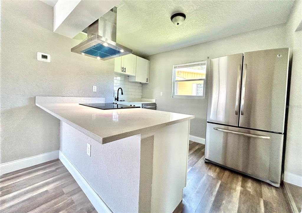 418 Charles Street Winter Garden, FL 34787 - Photo 9 of 27 a kitchen with kitchen island a sink appliances and cabinets