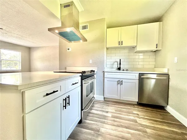 a kitchen with a sink stove and cabinets