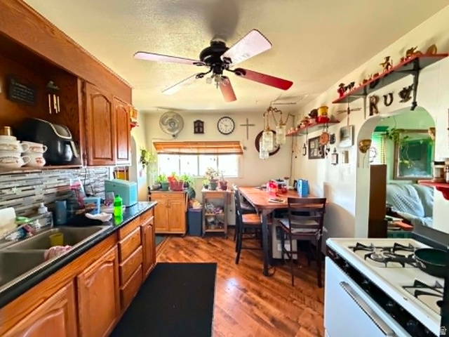 399 2nd E Street Helper, UT 84526 - Photo 2 of 19 Kitchen space featuring wood-finish flooring, a ceiling fan, and a window with wood blinds