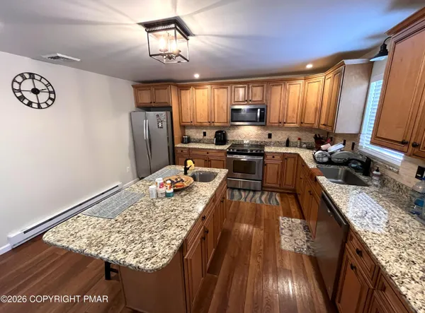 a view of a kitchen with kitchen island granite countertop lots of counter top space