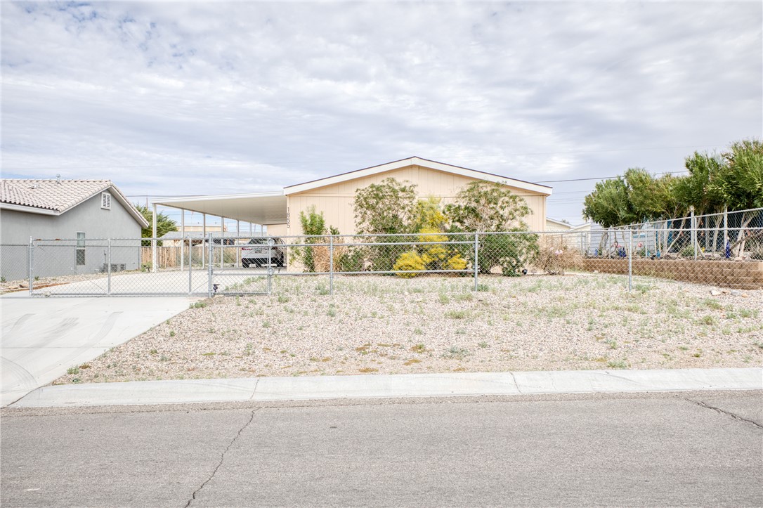 1855 Talc Road Bullhead City, AZ 86442 - Photo 1 of 23 View of front of home featuring driveway, a carport, and a gate