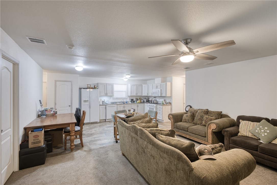 1855 Talc Road Bullhead City, AZ 86442 - Photo 5 of 23 Living room featuring a textured ceiling, a ceiling fan, and light carpet