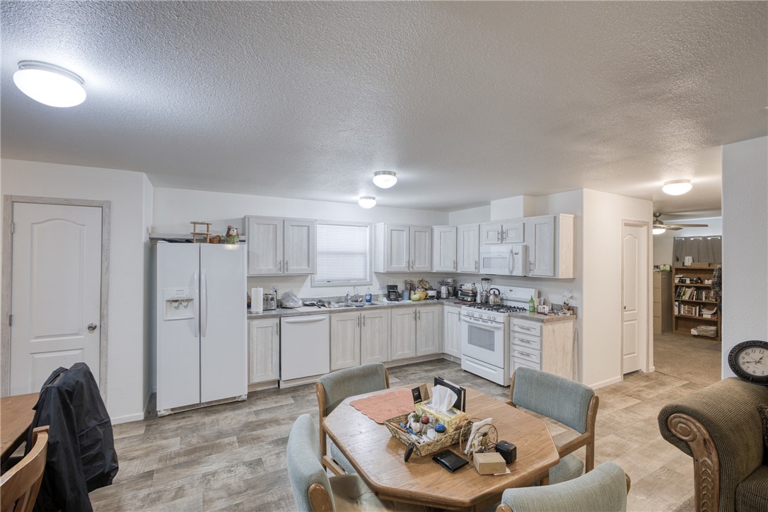 1855 Talc Road Bullhead City, AZ 86442 - Photo 6 of 23 Kitchen featuring white appliances, a textured ceiling, white cabinetry, light countertops, and ceiling fan