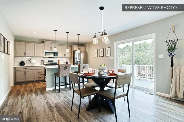 a view of a dining room and livingroom with furniture wooden floor a chandelier