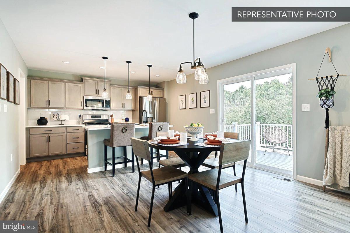 Sweet Birch Plan At Hills Spring Grove, PA 17362 - Photo 11 of 47 a view of a dining room and livingroom with furniture wooden floor a chandelier