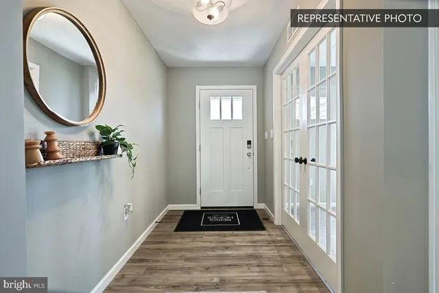 a view of a hallway with wooden floor and a bathroom