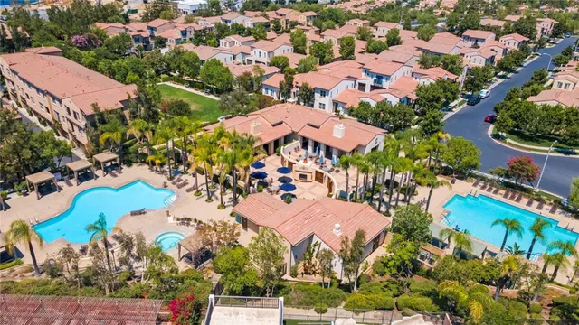 an aerial view of residential houses with outdoor space and parking