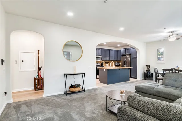 a living room with furniture a mirror and a chandelier
