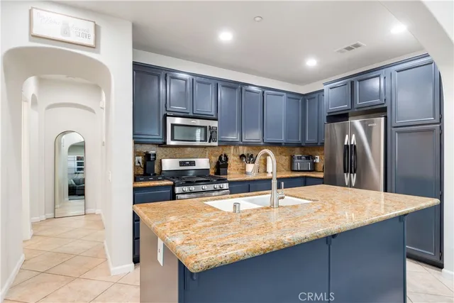 a kitchen with stainless steel appliances granite countertop a sink refrigerator and cabinets