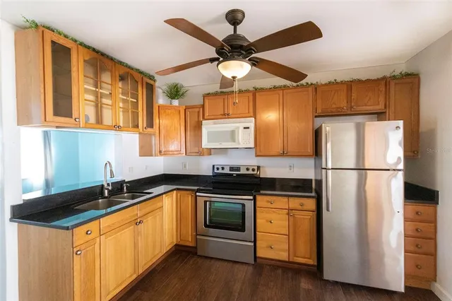 a kitchen with stainless steel appliances granite countertop a stove a sink and a refrigerator