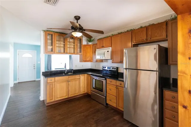 a kitchen with stainless steel appliances a refrigerator a sink and white cabinets