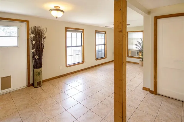 a view of an empty room with window and bathroom