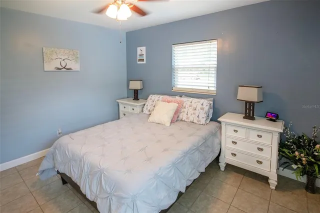 a bedroom with a bed and a chandelier fan
