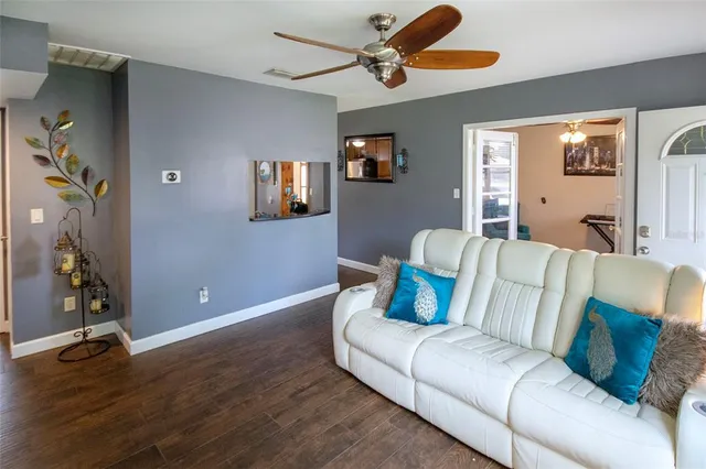 a living room with furniture and a ceiling fan