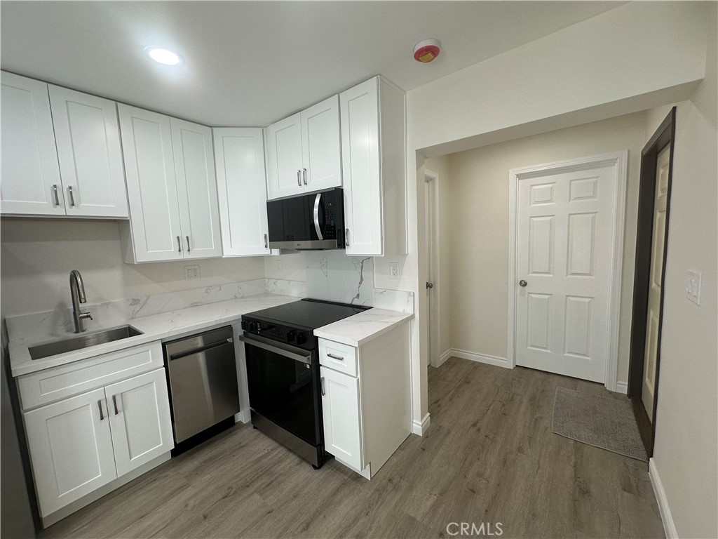 20655 Lemmer Street Chatsworth, CA 91311 - Photo 11 of 25 a kitchen with a sink stove and cabinets