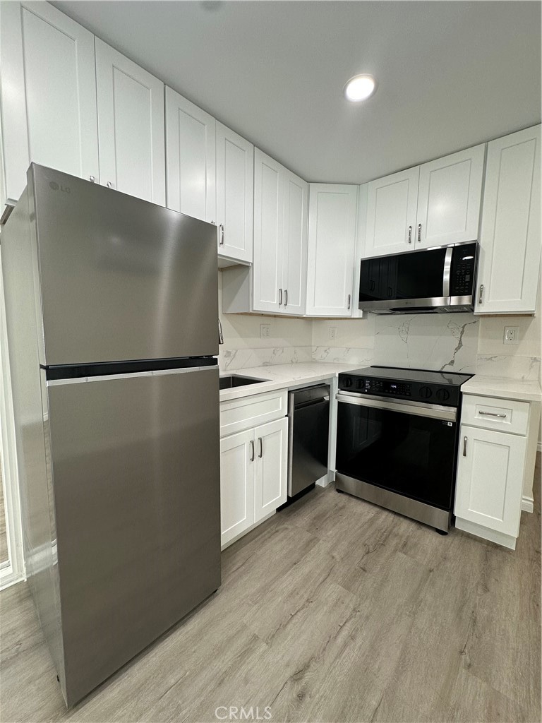 20655 Lemmer Street Chatsworth, CA 91311 - Photo 13 of 25 a kitchen with a refrigerator stove and microwave