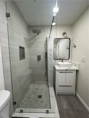 a bathroom with a sink a toilet a mirror and shower
