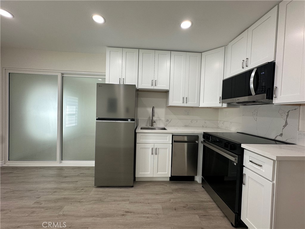 20655 Lemmer Street Chatsworth, CA 91311 - Photo 2 of 25 a kitchen with a refrigerator stove and microwave
