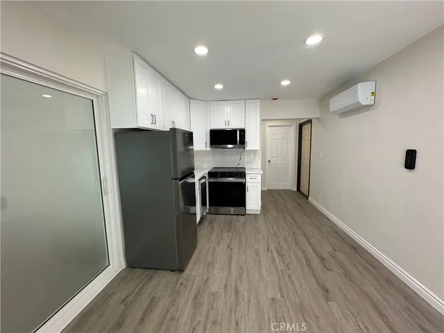 a kitchen with stainless steel appliances a refrigerator and a stove top oven