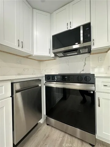 a kitchen with stainless steel appliances a stove microwave and sink