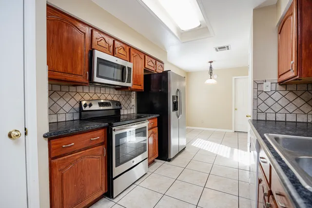 a kitchen with stainless steel appliances granite countertop a sink stove and microwave