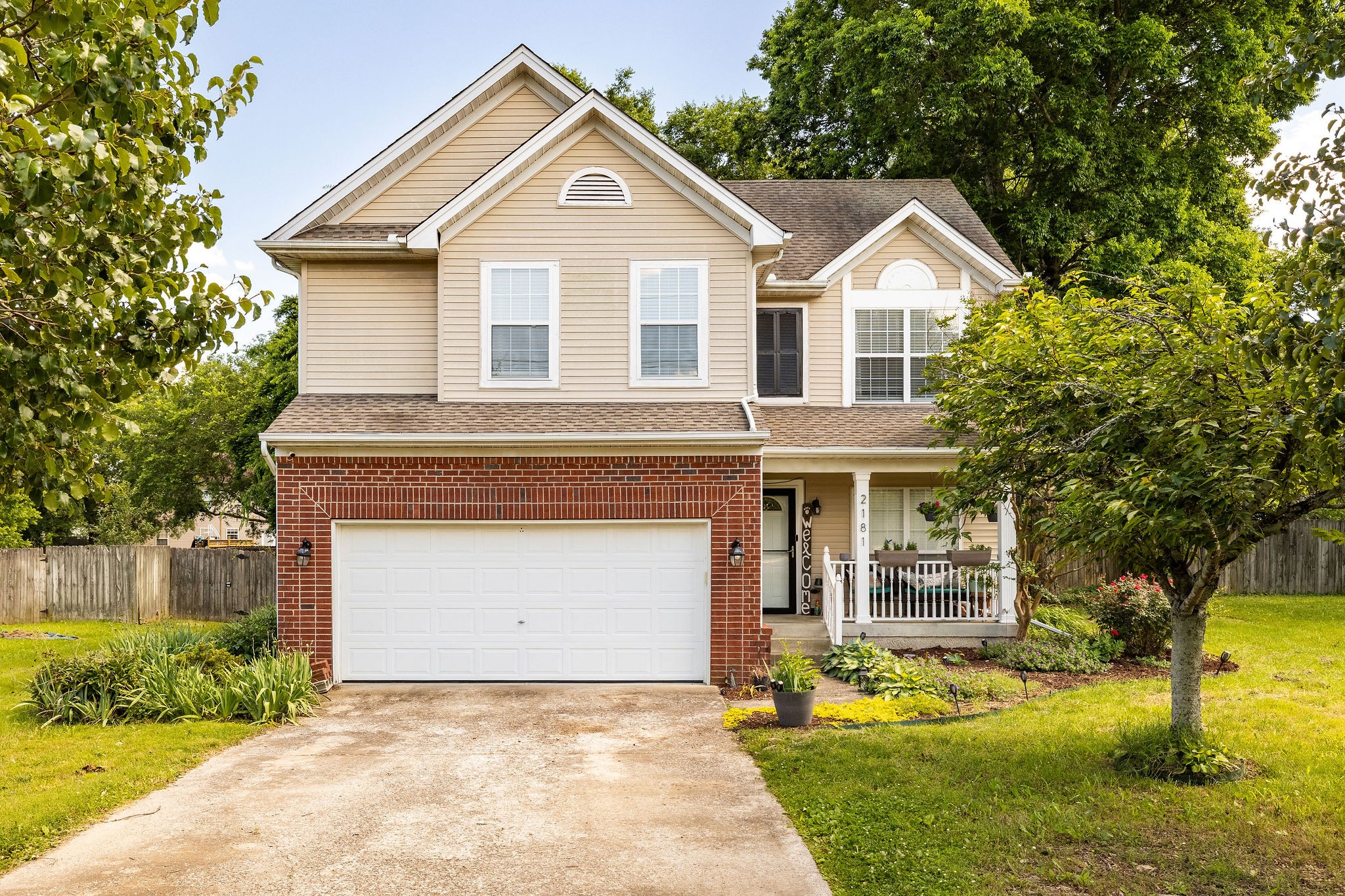 a view of a house with a yard and large tree