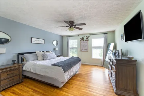 a spacious bedroom with a bed and a flat screen tv