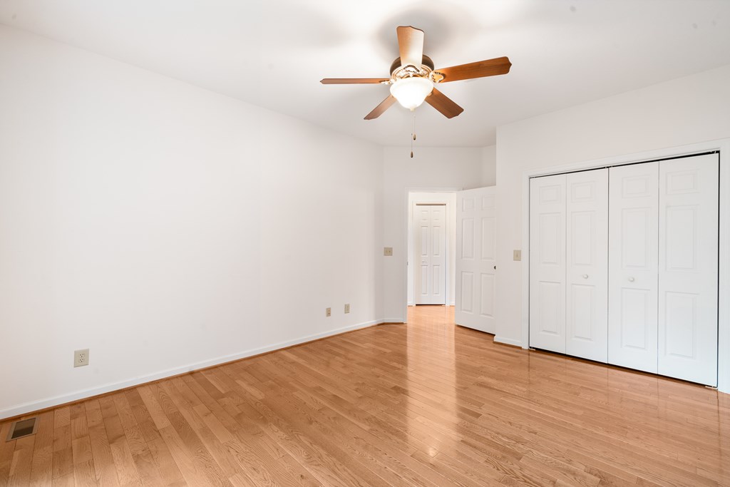 399 Hideaway Hills Road Blairsville, GA 30512 - Photo 33 of 77 an empty room with wooden floor fan and windows
