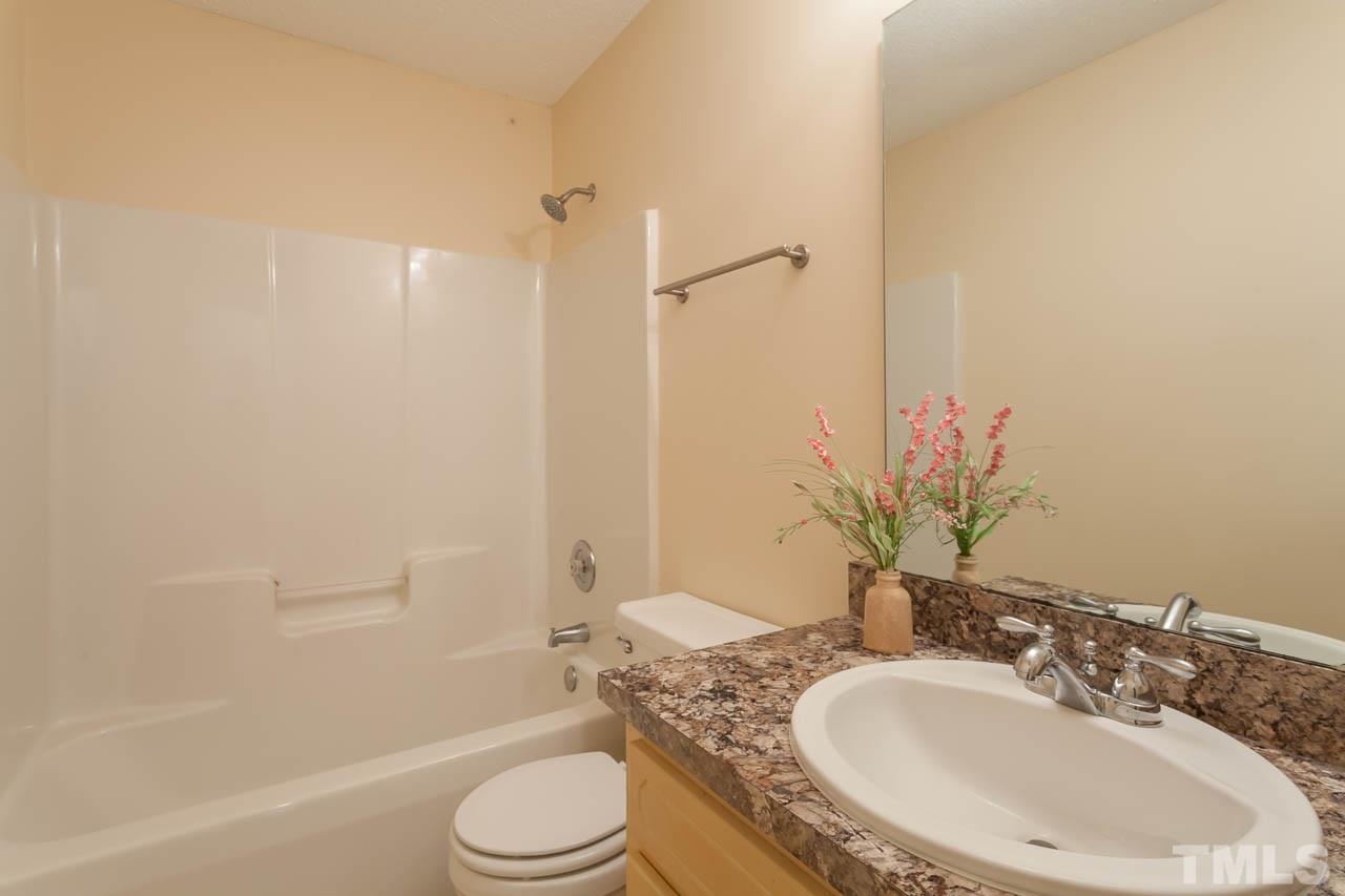 1388 Lee Road Clayton, NC 27520 - Photo 17 of 24 a bathroom with a granite countertop sink toilet and shower