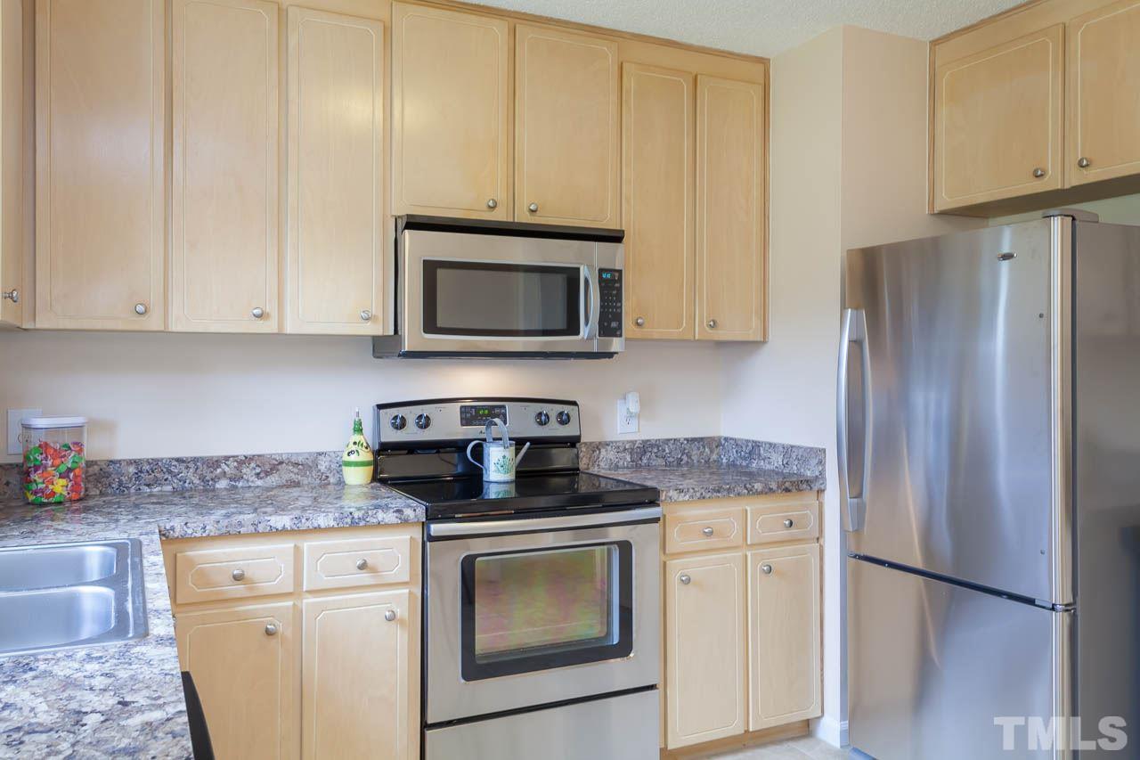 1388 Lee Road Clayton, NC 27520 - Photo 6 of 24 a kitchen with granite countertop white cabinets and stainless steel appliances
