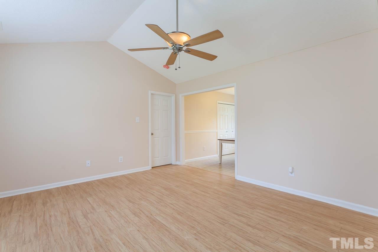 1388 Lee Road Clayton, NC 27520 - Photo 8 of 24 a view of a room with wooden floor and a ceiling fan