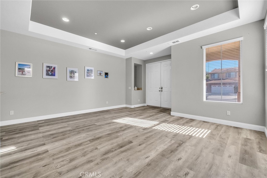 18388 Hidden Ranch Road Riverside, CA 92508 - Photo 7 of 46 an empty room with wooden floor and windows