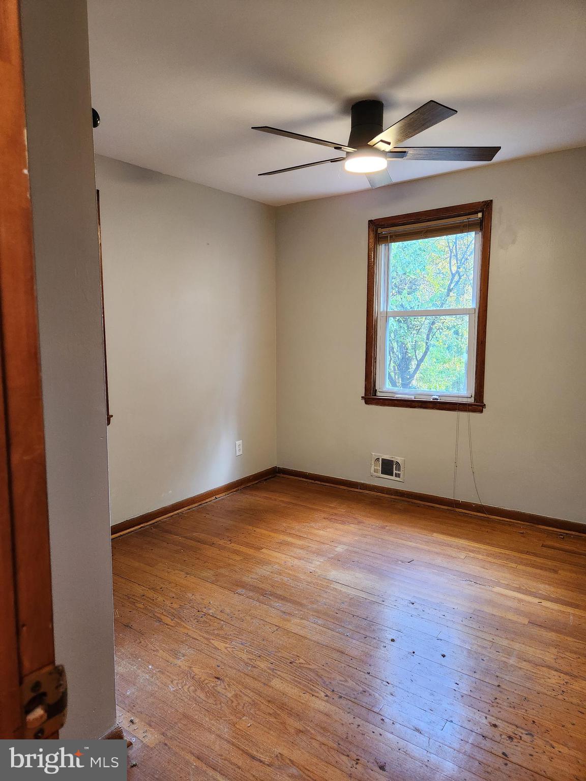 3817 Birchview Avenue, Unit 1 Baltimore, MD 21206 - Photo 7 of 19 an empty room with wooden floor and windows