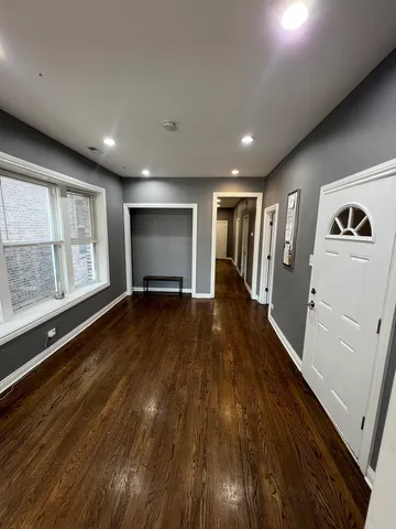 a view of a livingroom with wooden floor and a ceiling fan