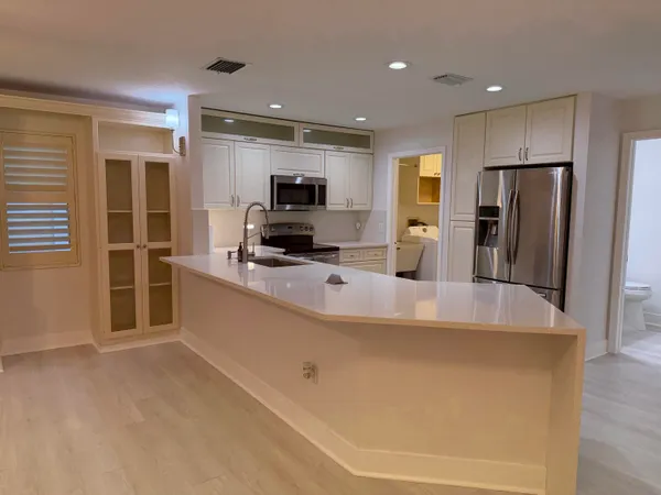 a large kitchen with a large counter top stainless steel appliances and cabinets