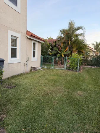 a view of a white house with a yard