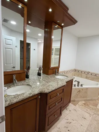 a spacious bathroom with a tub sink and mirror
