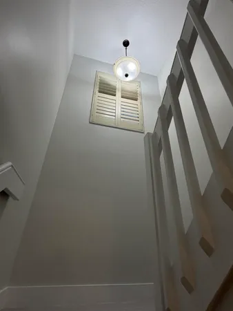 a view of empty room with wooden floor and window