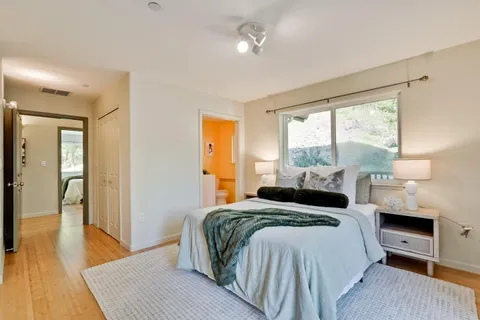 a bedroom with a bed and wooden floor
