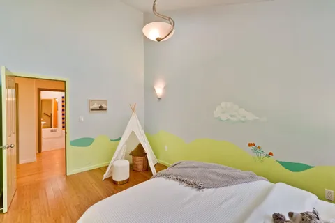 a bedroom with a bed and wooden floor