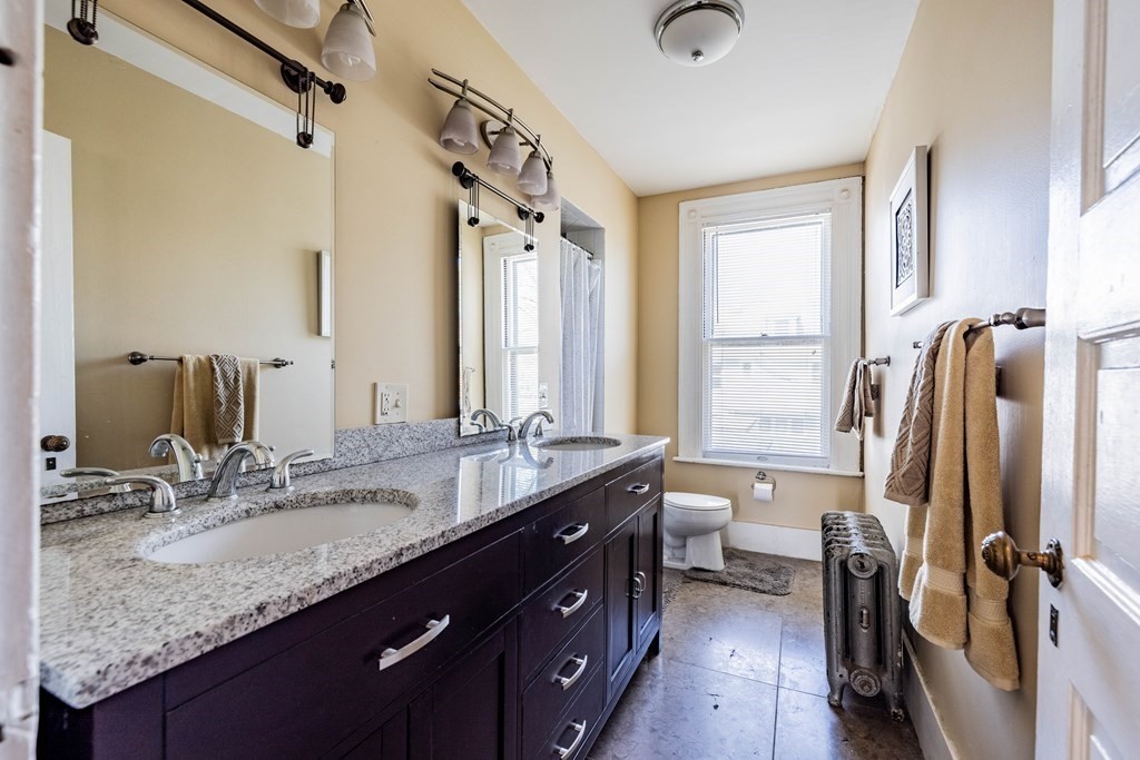 47 Magnolia Terrace Springfield, MA 01108 - Photo 26 of 37 a bathroom with a granite countertop sink a toilet and a mirror