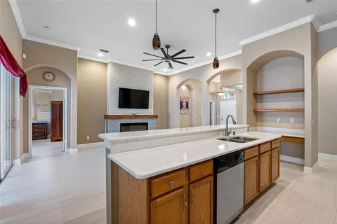 a view of a kitchen counter space a sink and a flat screen tv
