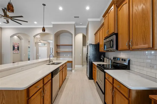 a kitchen with stainless steel appliances granite countertop a sink a stove and a refrigerator