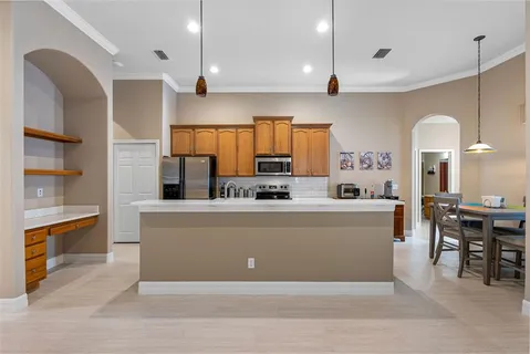 a view of kitchen with kitchen island stainless steel appliances a sink and living room view