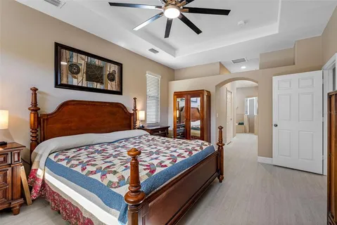 a bedroom with a large bed and a chandelier
