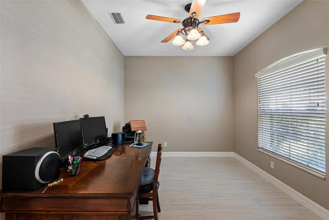 a view of a workspace with furniture and a window