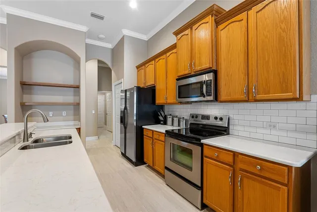 a kitchen with stainless steel appliances granite countertop a stove a sink and a microwave