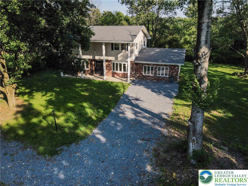 919 Point Phillips Road Bath, PA 18014 - Photo 52 of 59 Nestled among mature trees, this residence offers a gravel driveway and a welcoming front facade.