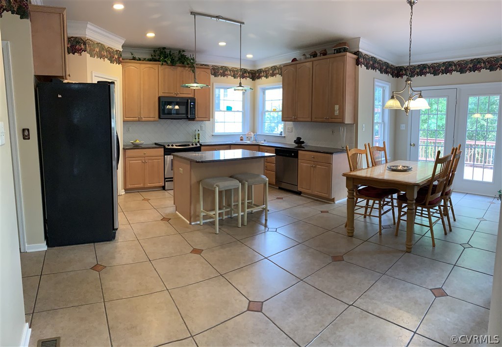 1400 Goswick Ridge Road Midlothian, VA 23114 - Photo 3 of 24 a kitchen with stainless steel appliances kitchen island granite countertop a table chairs and a refrigerator